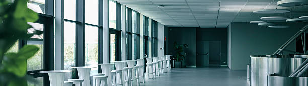 istock Modern minimalist interior with tables and chairs along a large window. 2240084312
