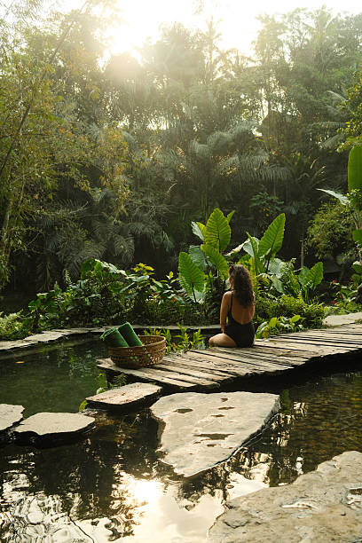 istock Woman relaxing in tropical spa amid lush jungle 2240084878