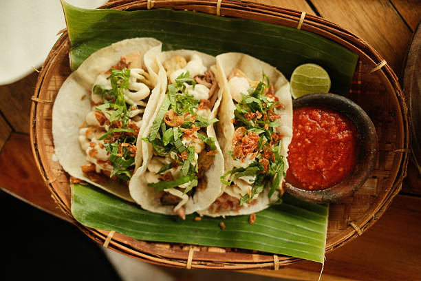 Spicy tacos with salsa, lime, and banana leaf