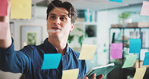 istock Writing, tablet and man in office with sticky note, brainstorming or financial solution in agency. Budget plan, mindmap or person in workplace with technology, problem solving and business strategy. 2240085937