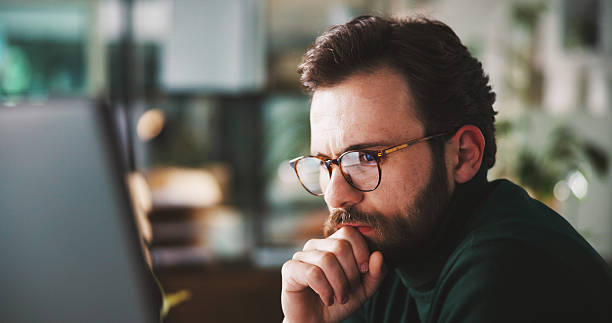 istock Businessman, computer or reading in office with thinking, planning or corporate review with glasses. Male person, problem solving or research analysis by tech, email or feedback insight at workplace 2240085967