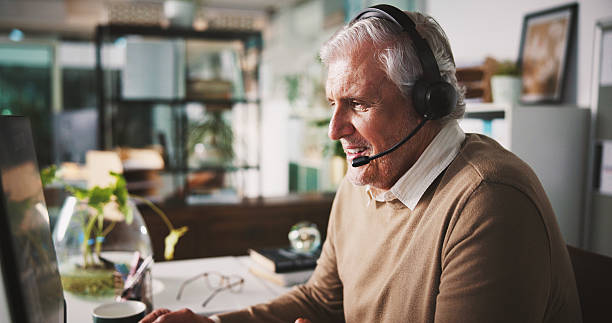 istock Communication, headset and mature man in office with computer for customer service, advice and hotline. Client query, contact us or help desk agent with pc for complaint solution, faq or tech support 2240085981