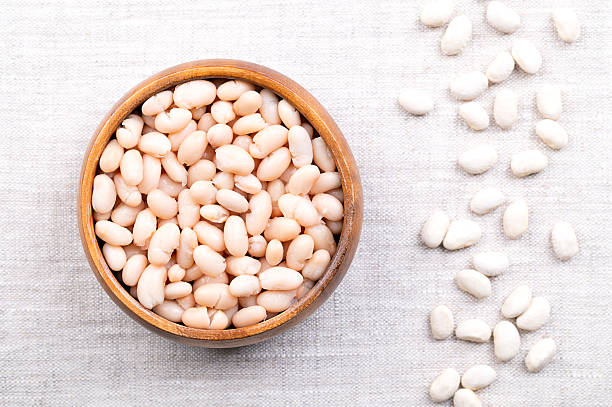 istock Cooked white beans, in a wooden bowl on linen 2240090524