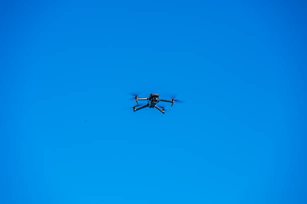 istock Drone flies in the blue sky 2240092412