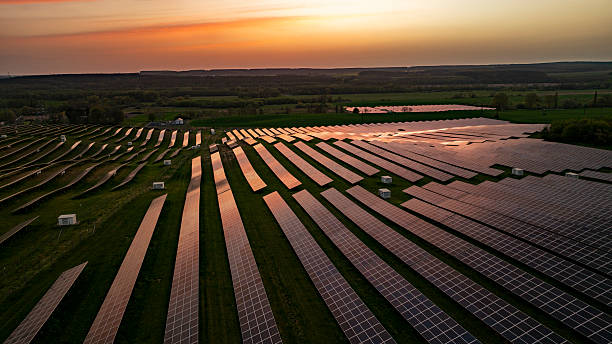 istock Expansive Solar Panel Field at Sunset with Vibrant Sky and Green Landscape 2240092824