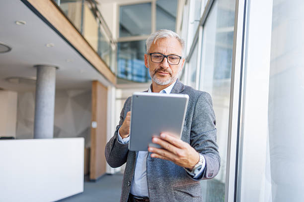 istock Mature businessman working with digital tablet in modern office 2240093037