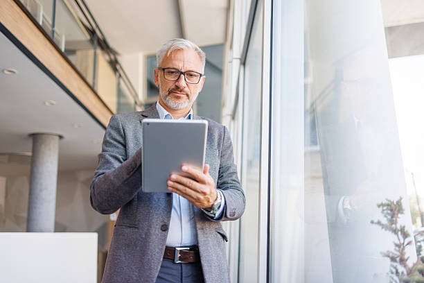 istock Mature businessman working on digital tablet in modern office 2240093052
