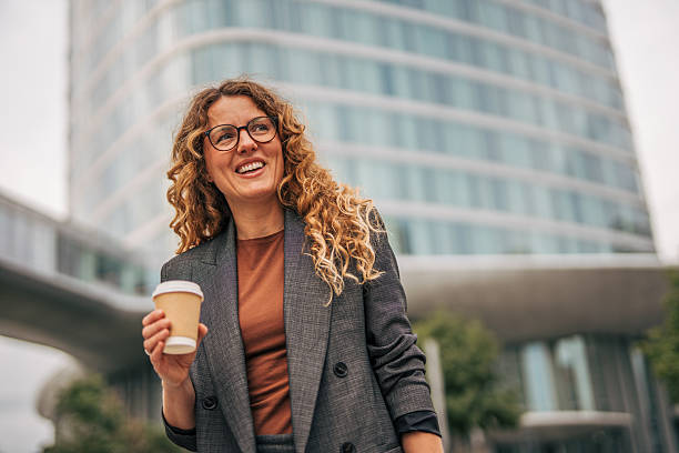 istock Businesswoman holding coffee cup in urban setting 2240093210