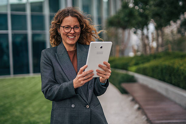 istock Professional woman happily using digital tablet outdoors 2240093404