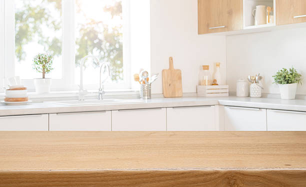 istock Wooden table top for food presentation with blurred modern kitchen counter interior background 2240093471