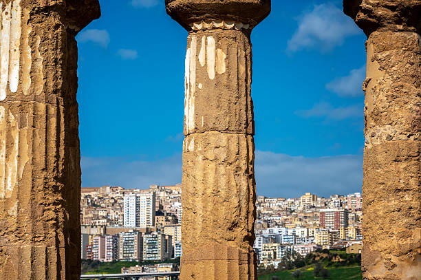 Temple of Castor and Pollux in Agrigento, Italy in the Valley of the Temples with the modern city visible in the background