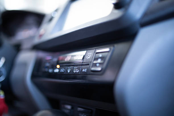 A detailed close-up stock photo of a modern car’s instrument panel featuring climate control and air conditioning buttons. The image highlights the precision, design, and technology of automotive interiors , perfect for illustrating comfort, innovation, and vehicle control concepts.