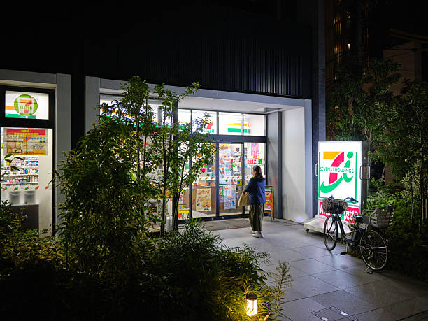 Tokyo, Japan - October 9, 2025:  Customers walk into a 7-11 convenience store at night in the Koto Ward of Tokyo, Japan.
