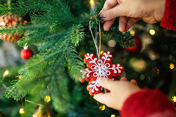 istock Child decorating Christmas tree with gingerbread cookies 2240104481