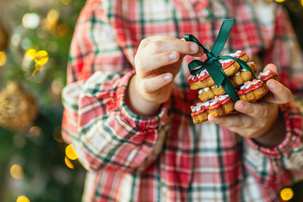 istock Child with gingerbread cookies near Christmas tree 2240104513