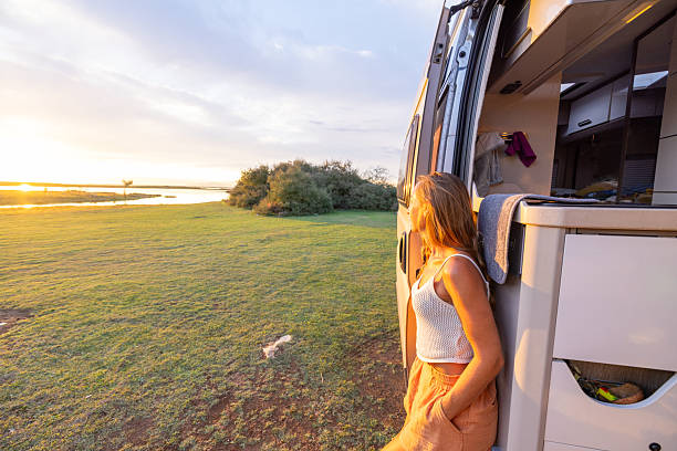 istock Woman Relaxing Outside Camper Van at Sunset 2240104929