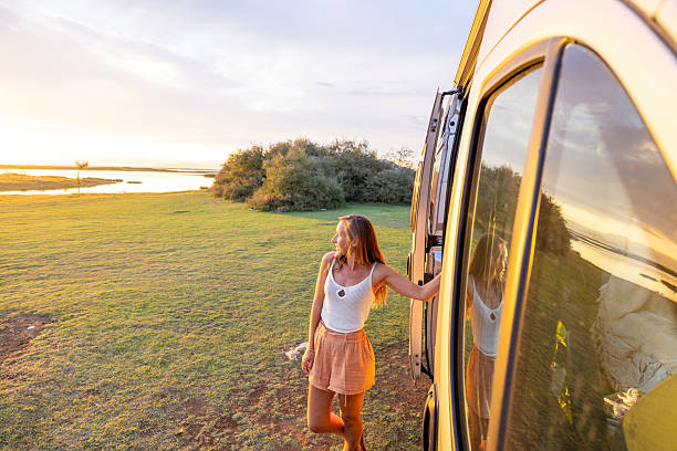 istock Woman Relaxing Outside Camper Van at Sunset 2240105022