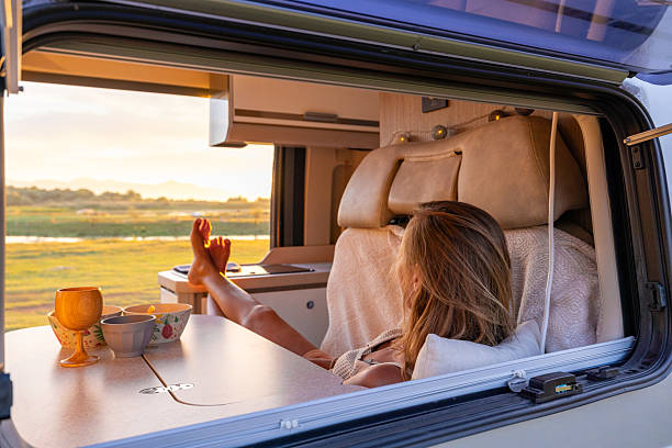istock Woman Relaxing Inside Camper Van at Sunset 2240105060