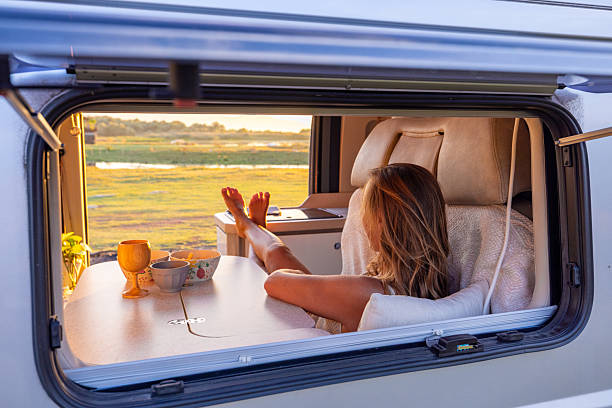 istock Woman Relaxing Inside Camper Van at Sunset 2240105102