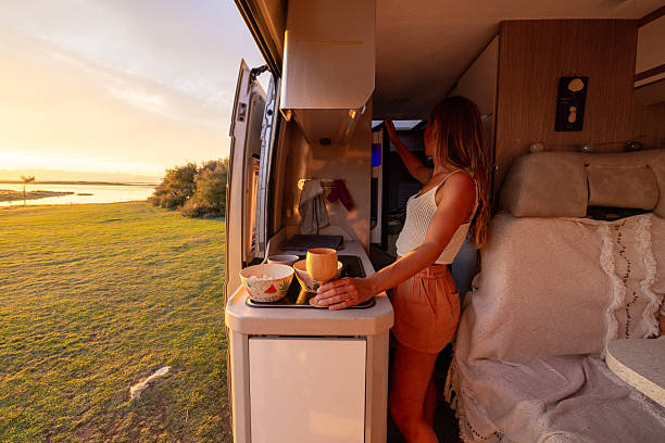 istock Woman Preparing Drink Inside Camper Van at Sunset 2240105245