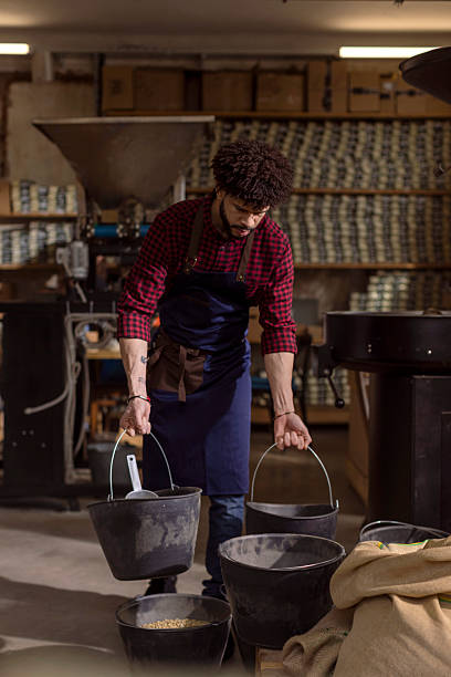 istock Artisan Brewer Grading Beans in Roastery Workshop With Buckets and Burlap Bags 2240106021