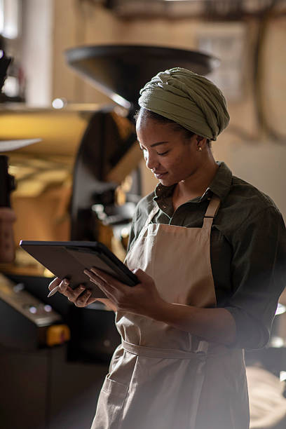 istock Young Woman in Apron Using Tablet at Coffee Roasting Facility 2240106056