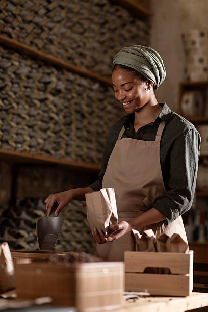 istock Smiling Worker in an Artisan Shop Packaging Products Into Bags 2240106077