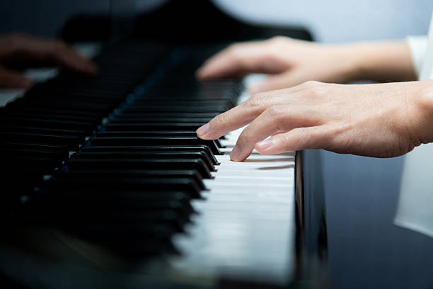 istock Woman's hands playing the piano 2240107137