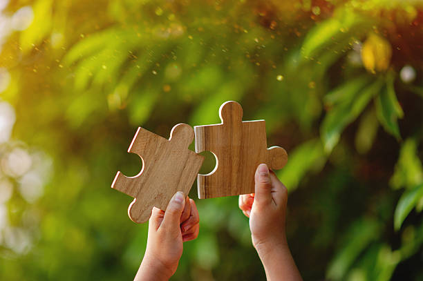 istock Cooperation in teamwork, expression through the use of wooden jigsaw puzzles, unity and teamwork. 2240113551