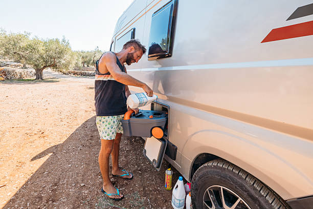 istock Man Maintaining Camper Van Waste Tank Outdoors 2240113899