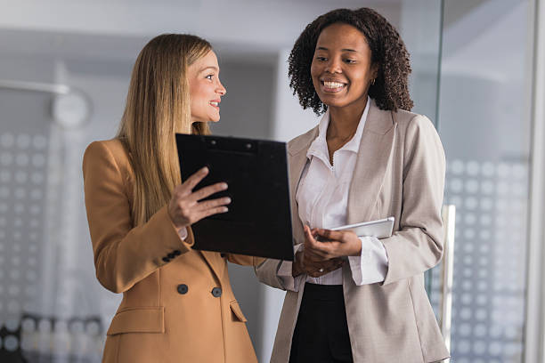 istock Diverse businesswomen collaborating on document in office 2240114163
