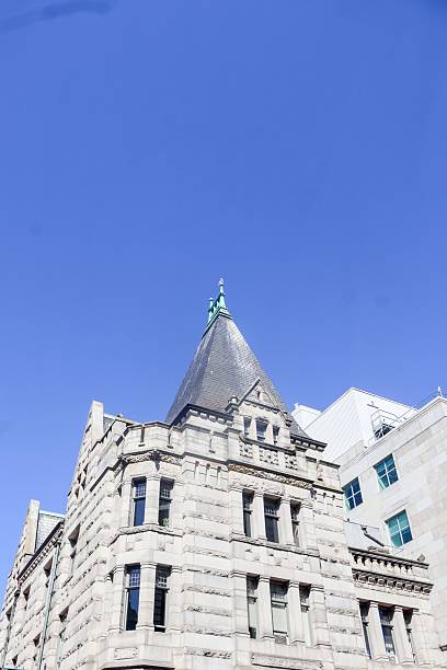 istock Historic stone building with a pointed roof under a clear blue sky. 2240114369