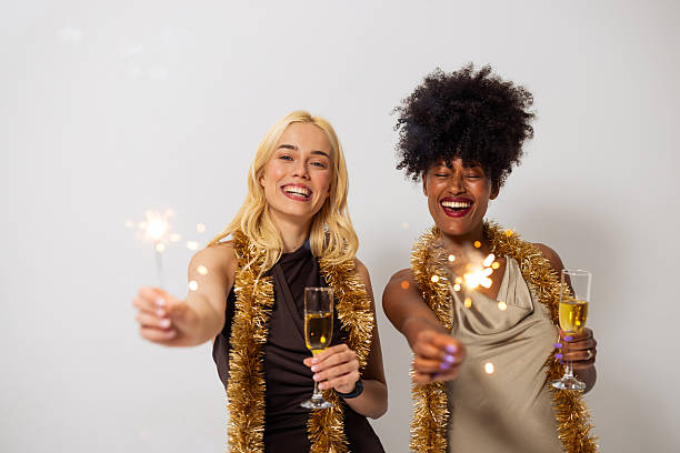 istock Two diverse young women celebrating with sparklers and champagne 2240117253