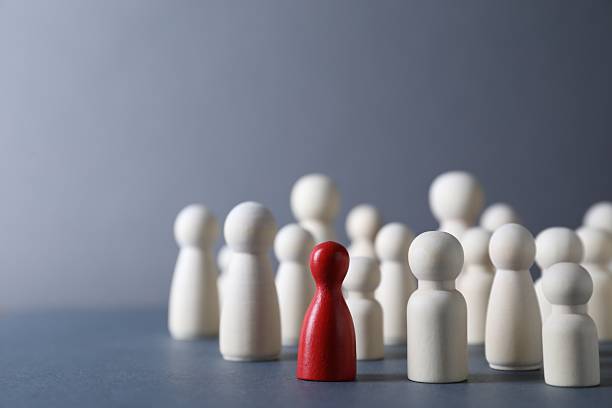 istock Human resources concept. Red figure among wooden ones on grey background, closeup. Space for text 2240117577