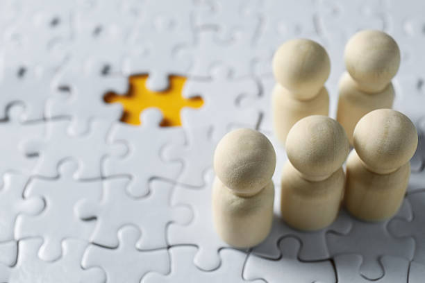 istock Human resources concept. Many wooden figures on puzzles, closeup 2240117695