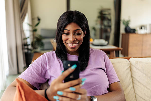 istock Black Woman Using Mobile Phone at Home 2240118417