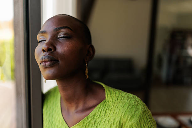istock Calm Black Bald Woman by the Window 2240119025
