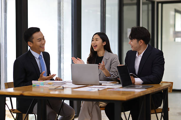 istock Group businesspeople happy while collaborating on a new project in an office. Businessman leading a discussion during a meeting with colleagues. Businesswoman interacting with a colleague. 2240122075