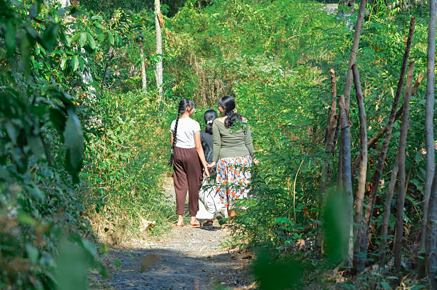 istock Three teenage girls joyfully chatting while walking along a forest trail 2240123222