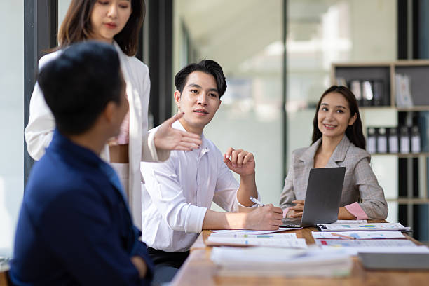 istock Group businesspeople happy while collaborating on a new project in an office. Businessman leading a discussion during a meeting with colleagues. Businesswoman interacting with a colleague. 2240123389