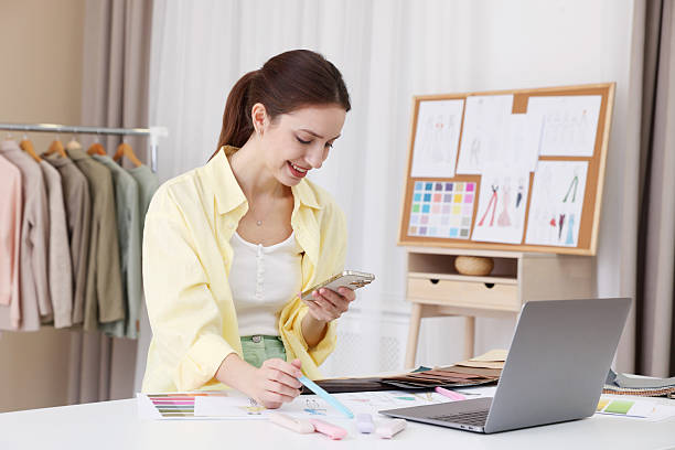 istock Fashion designer using smartphone at white table in workshop 2240123852