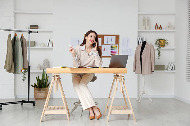 istock Fashion designer talking on smartphone at wooden table in workshop 2240123901