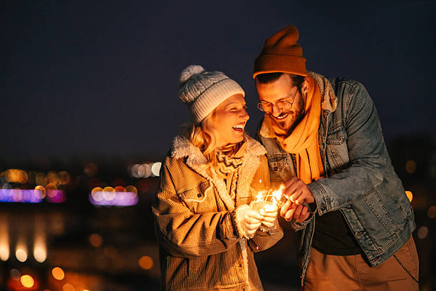 istock Happy Couple Laughing with Sparklers at Night 2240128015
