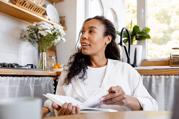 istock Woman journaling and relaxing in bright kitchen 2240129053