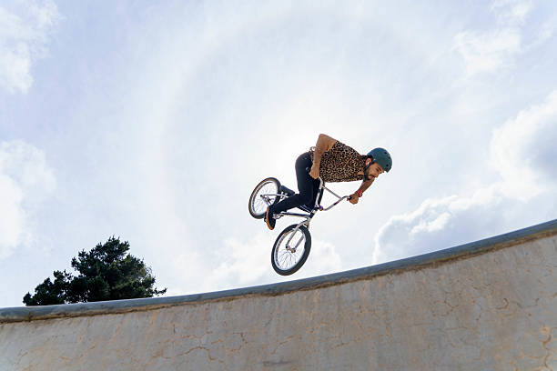 istock Latin american man performing bmx trick in skate park 2240130676