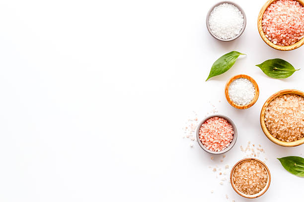 Spa composition with many different kinds of sea salt in bowls, top view.