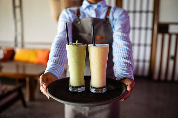 Modern dining experience, a waitress with smoothies on a tray in a stylish eatery offering friendly service and a cozy vibe for a memorable visit today