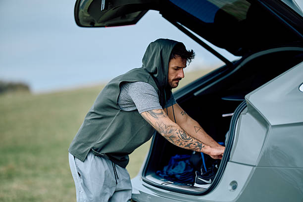 istock Man preparing outdoors for fitness activity from car trunk 2240135176