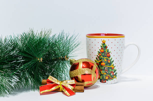 a christmas mug with ornaments and pine branch on white background