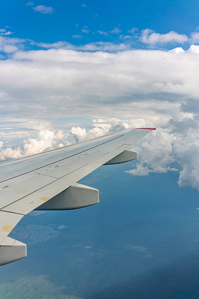 istock View from the airplane window at a beautiful cloudy sky and the airplane wing 2240137624